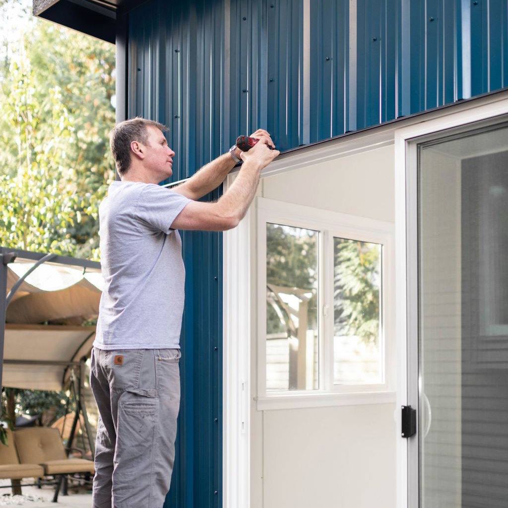 A builder works on a backyard office shed in Vancouver BC